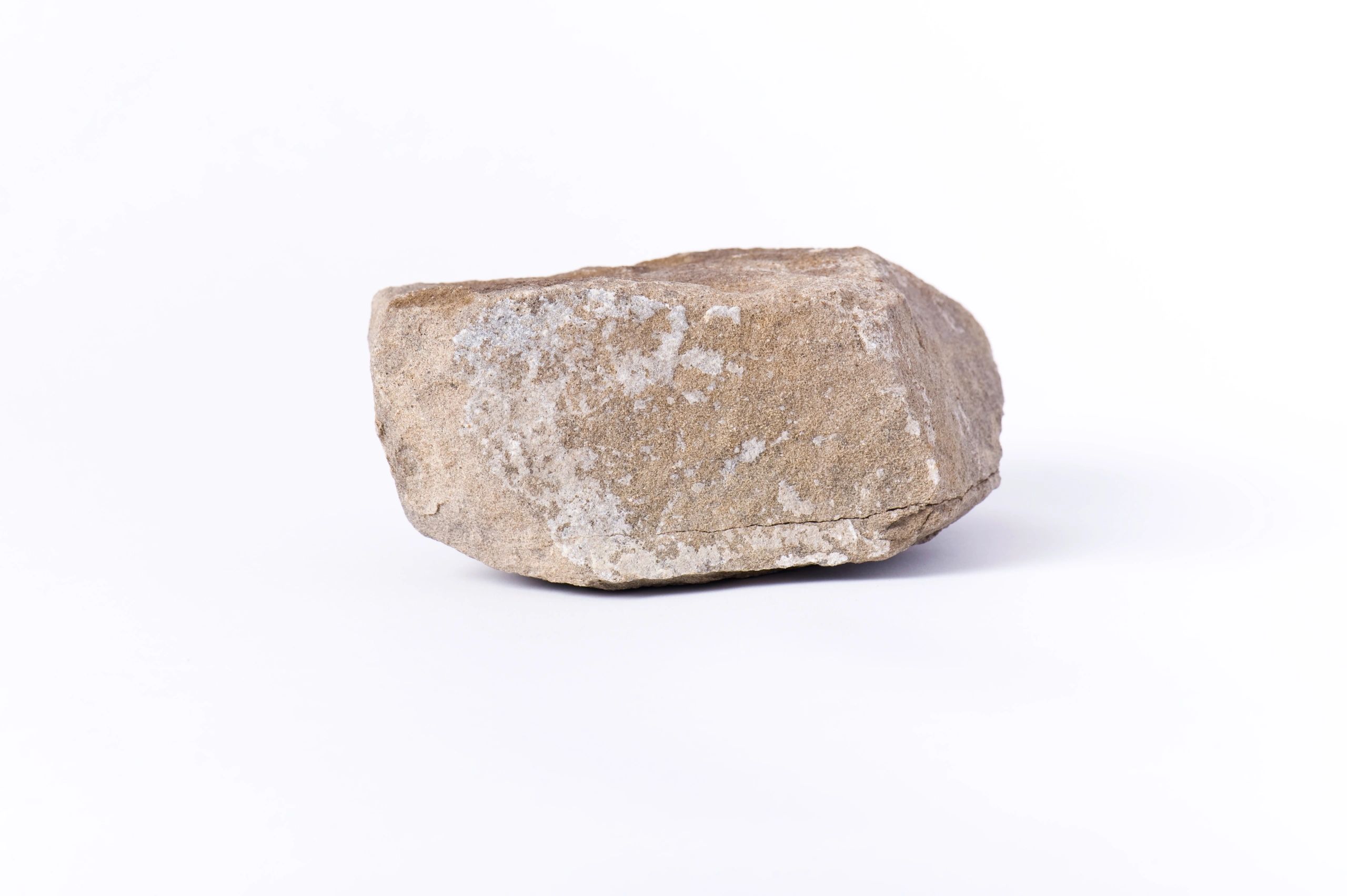 Dark, dense stone specimen isolated on a light background