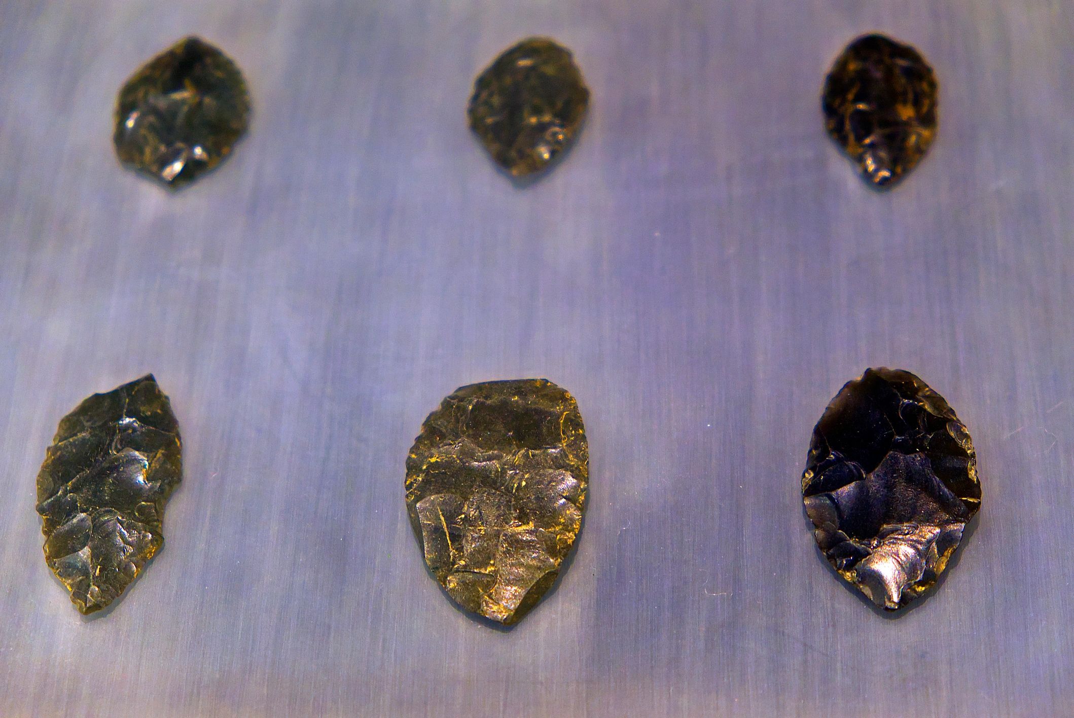 Neolithic obsidian arrowhead on dark background