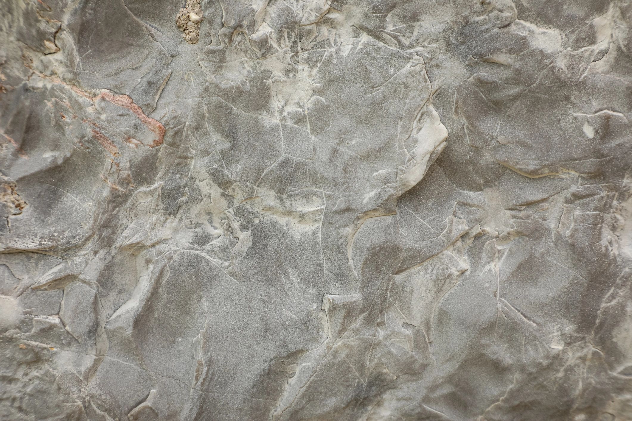 Weathered stone surface with fine cracks and mineral veins