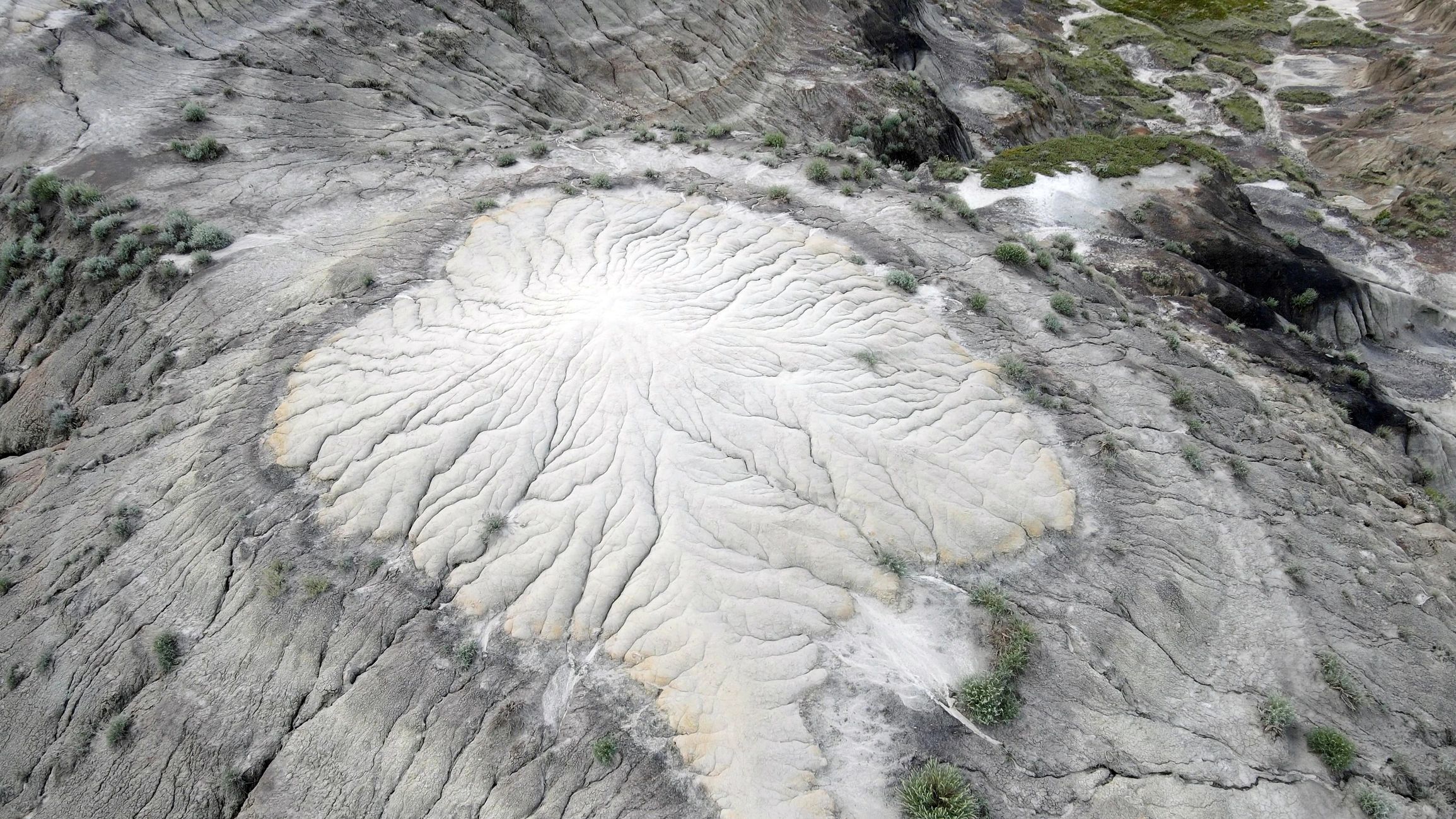 Aerial view of eroded badlands with exposed sedimentary stratification