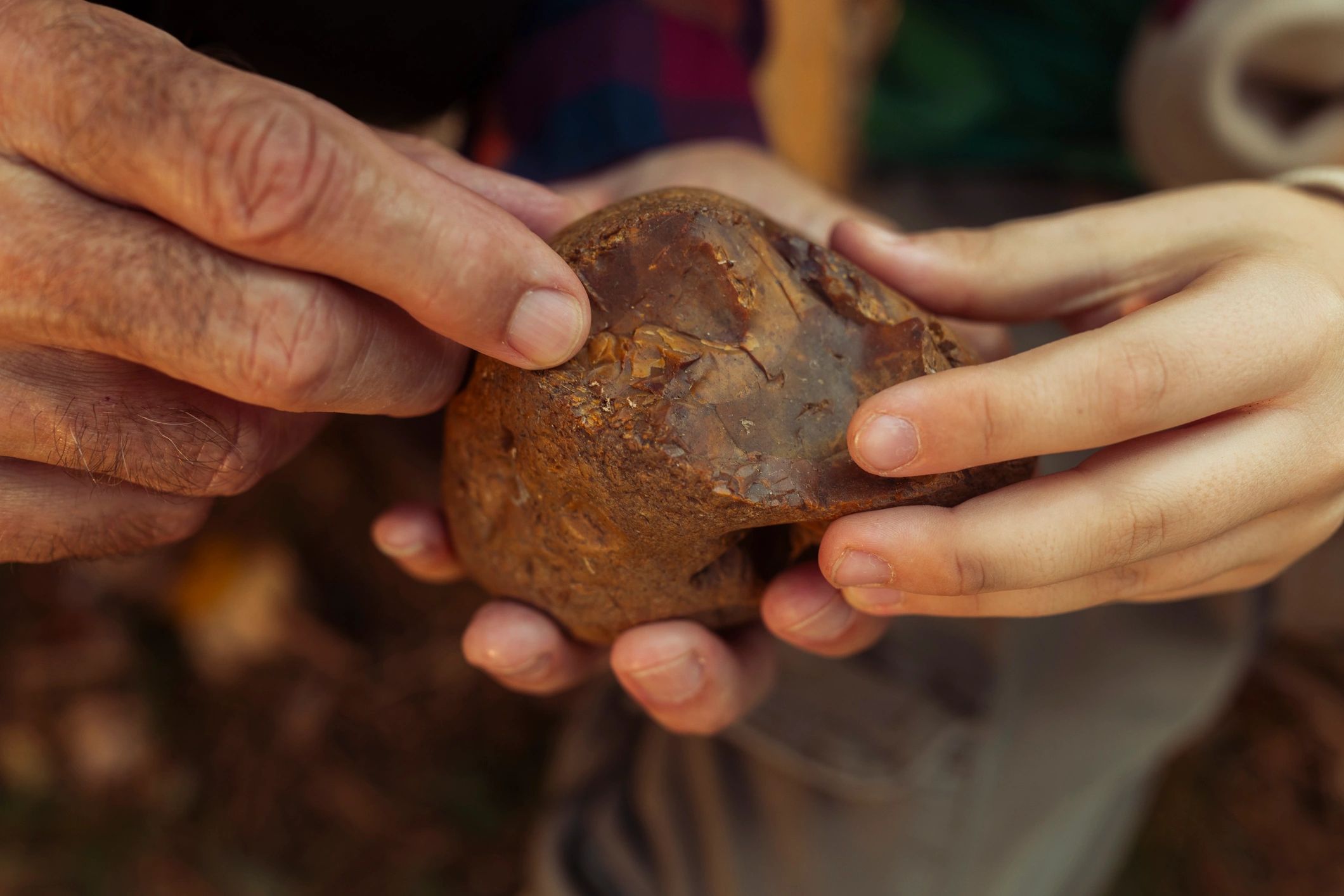 Hands holding a stone specimen representing archaeology and identification