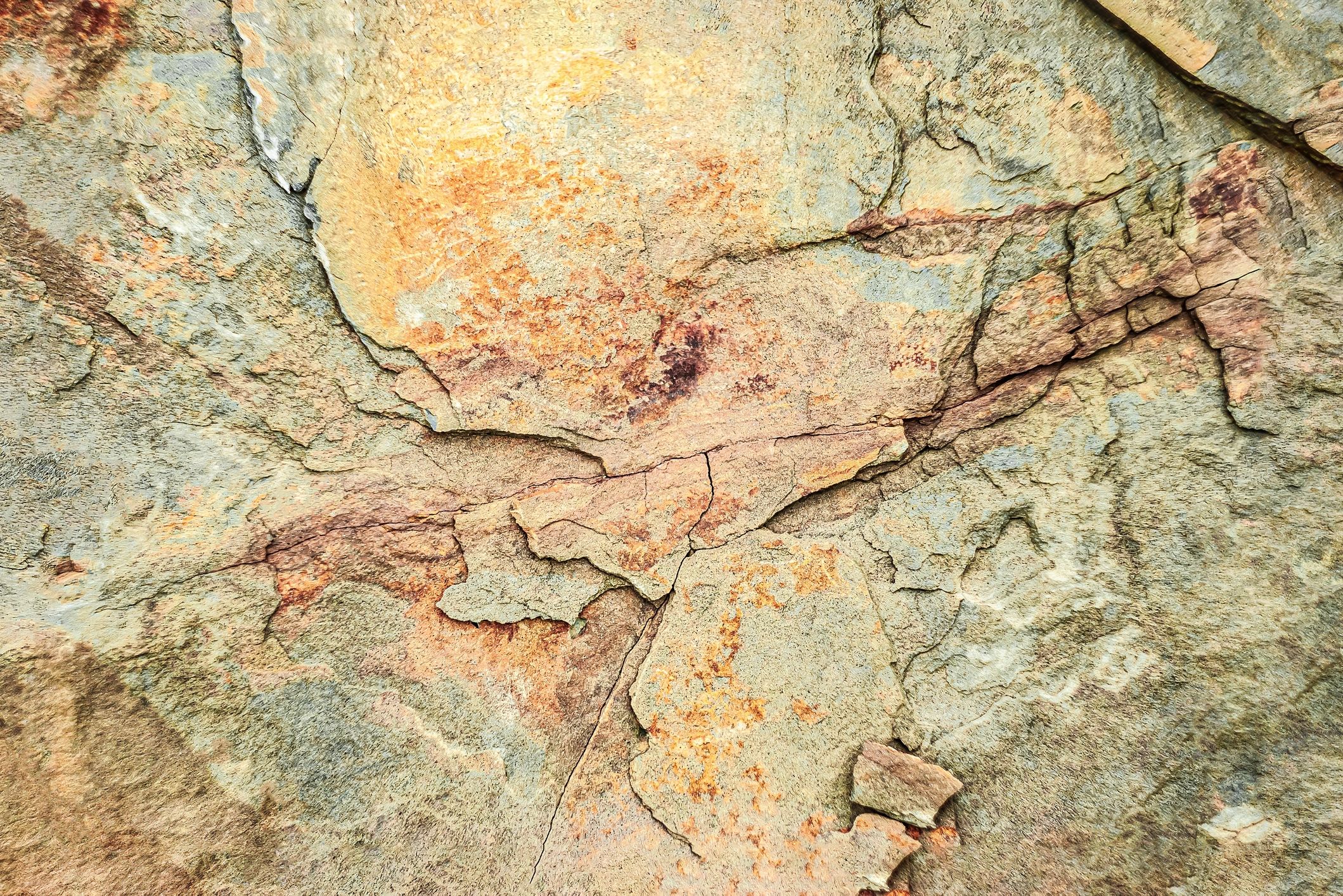 Textured rock surface with orange and brown hues in natural light