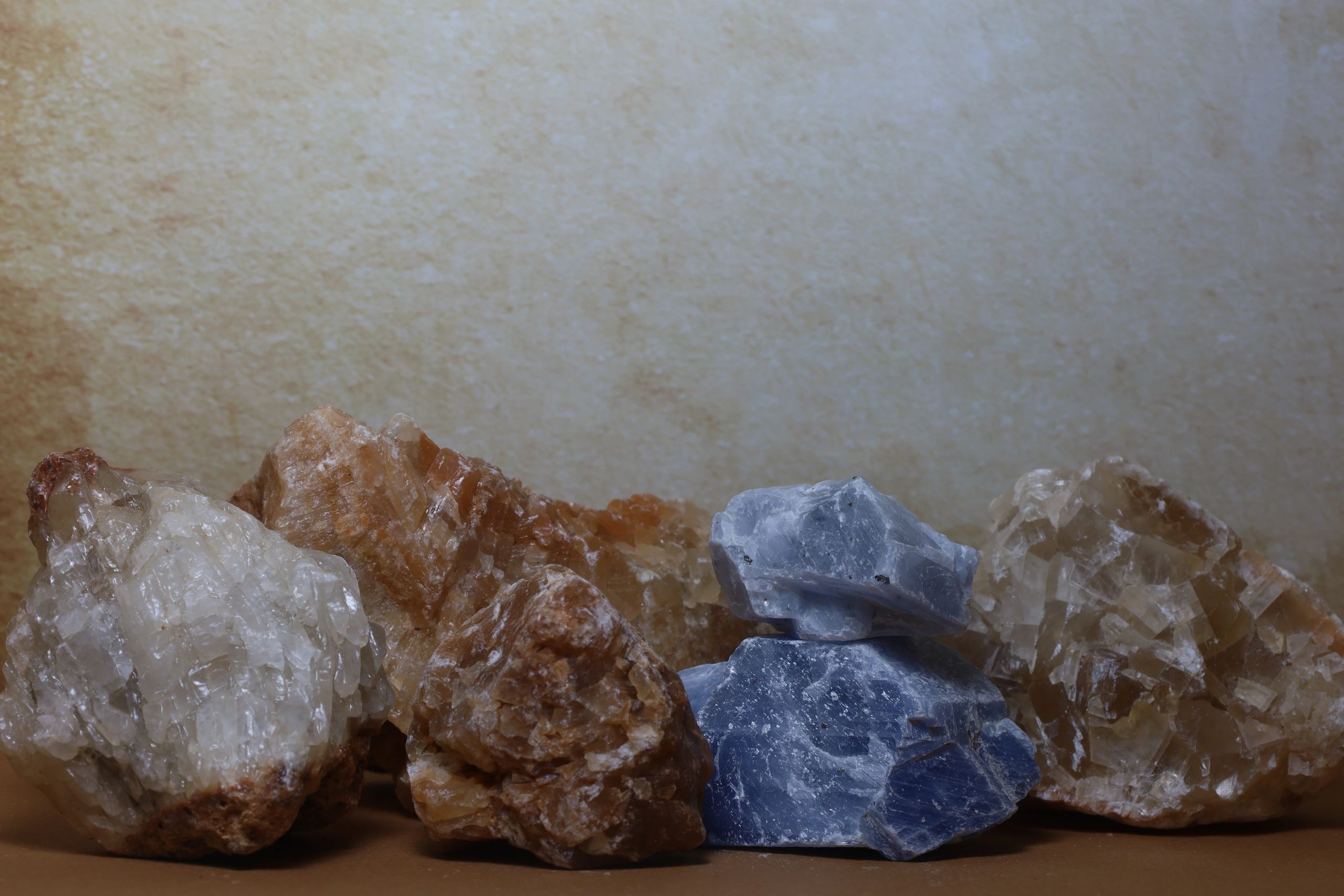Assorted raw mineral specimens on neutral background