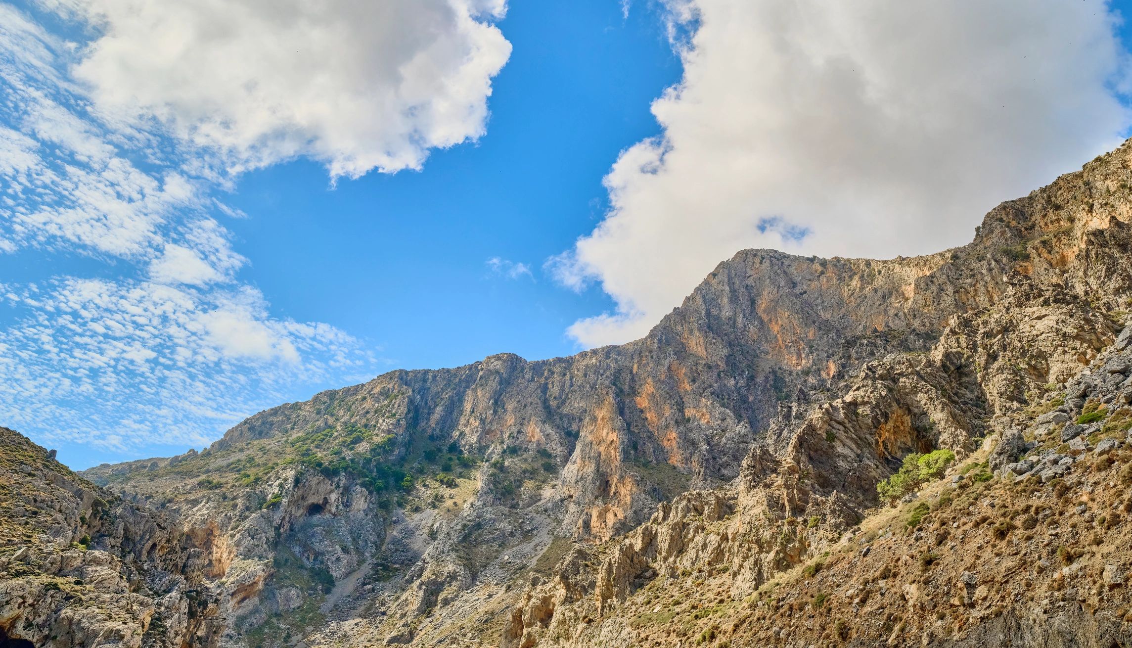 Rugged limestone mountain ridges under a blue sky
