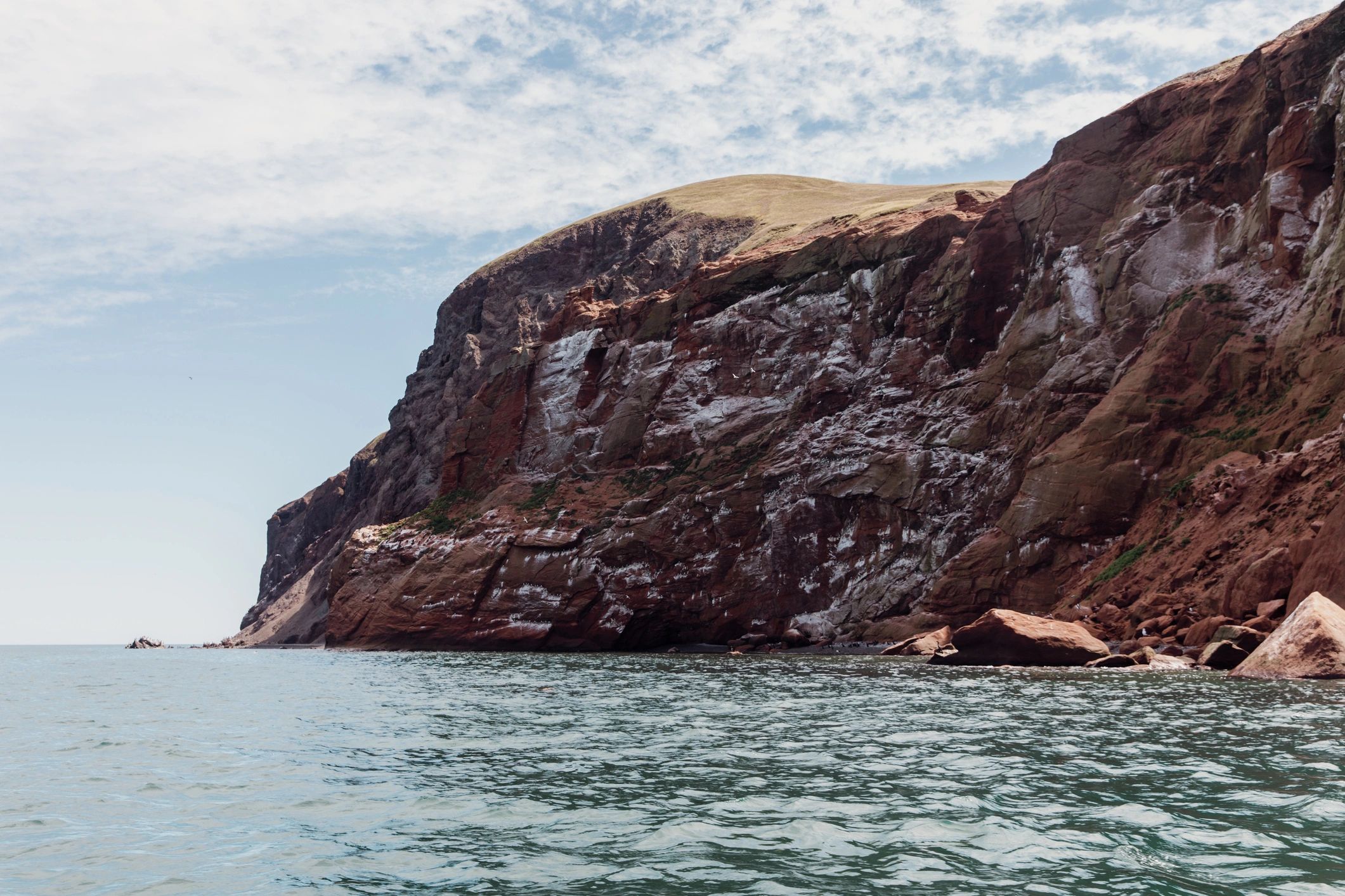 Red sandstone cliffs above turquoise water